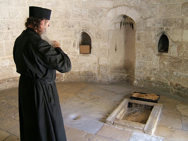 Monk praying at the Ascension Chappel in Jerusalem