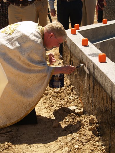 Fr David paints the cross on each of the cardinal directions of foundation