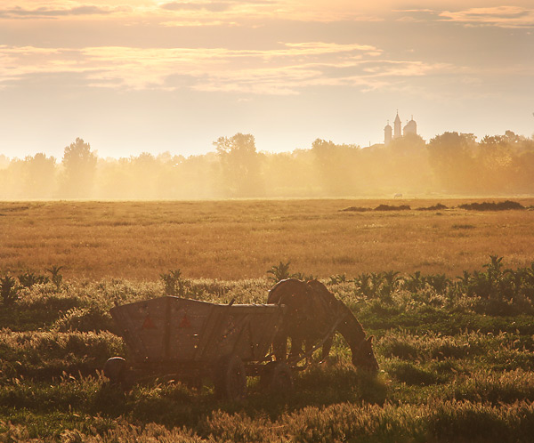 Sunset with two horses, light rain and church