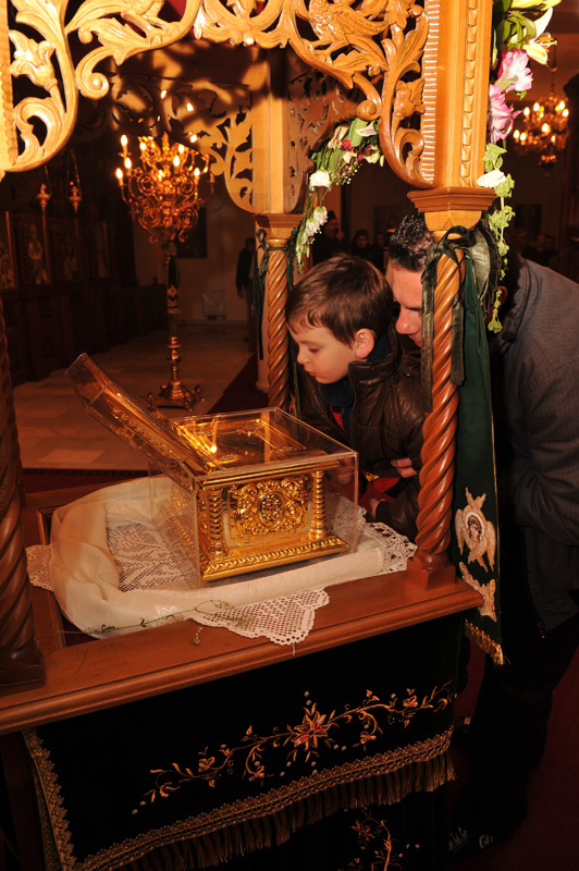 Father and son embrace in faith the relics of St. Luke the Doctor