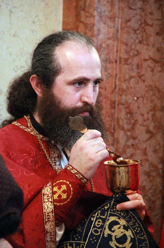 Orthodox priest distributing Holy Eucharist in Sameba Cathedral in Tbilisi