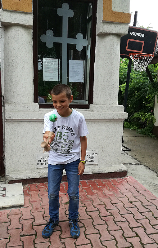 Marian, one of the priest&#039s sons, playing kendama after the Divine Liturgy at the Nefliu Parish.