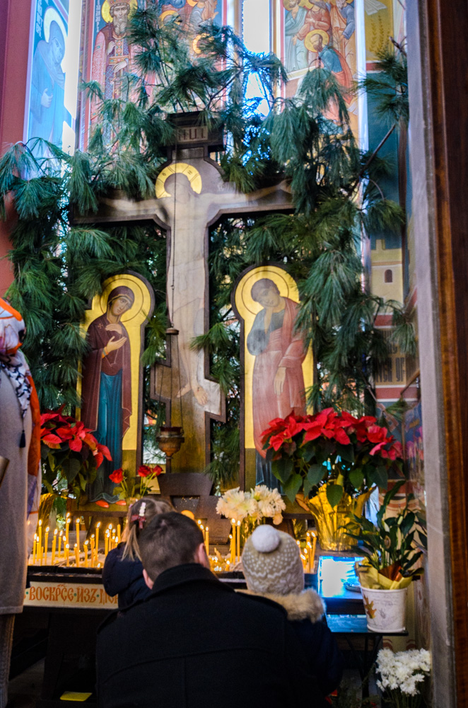 Father and daughters light candles before Liturgy