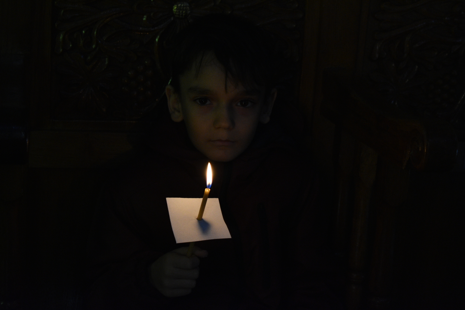 Față de copil luminată de lumânare