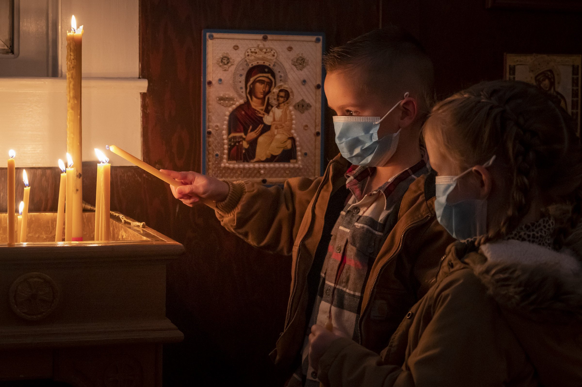 Siblings light a candle during Christmas Eve vigil, Бадиње вече, St. Sava Jackson