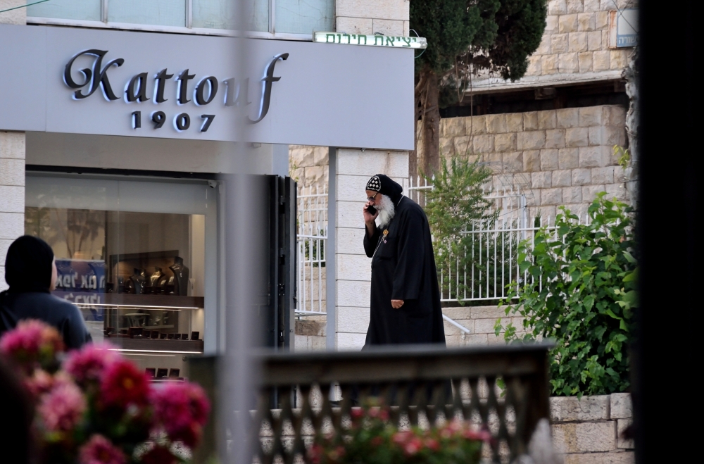 Contrast - Muslim woman and Coptic monk in front of the Eastern Orthodox Centre, Nazareth
